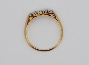 An early 20th century yellow metal and graduated five stone diamond set half hoop ring, size N, gross weight 2 grams. Condition - fair